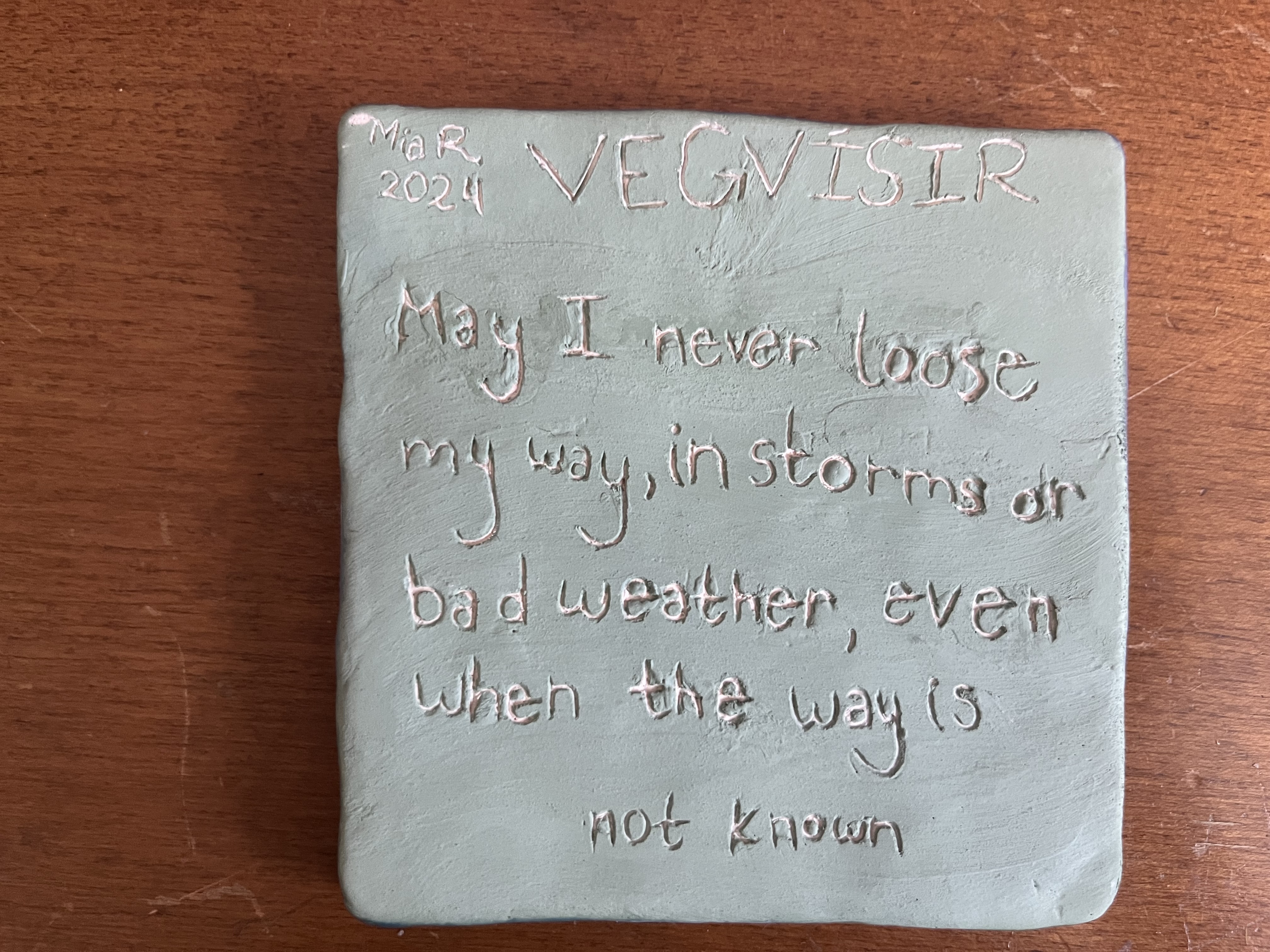 The back of the tile with the description: VEGVISIR May I never loose my way, in storms or bad weather, even when the way is not known