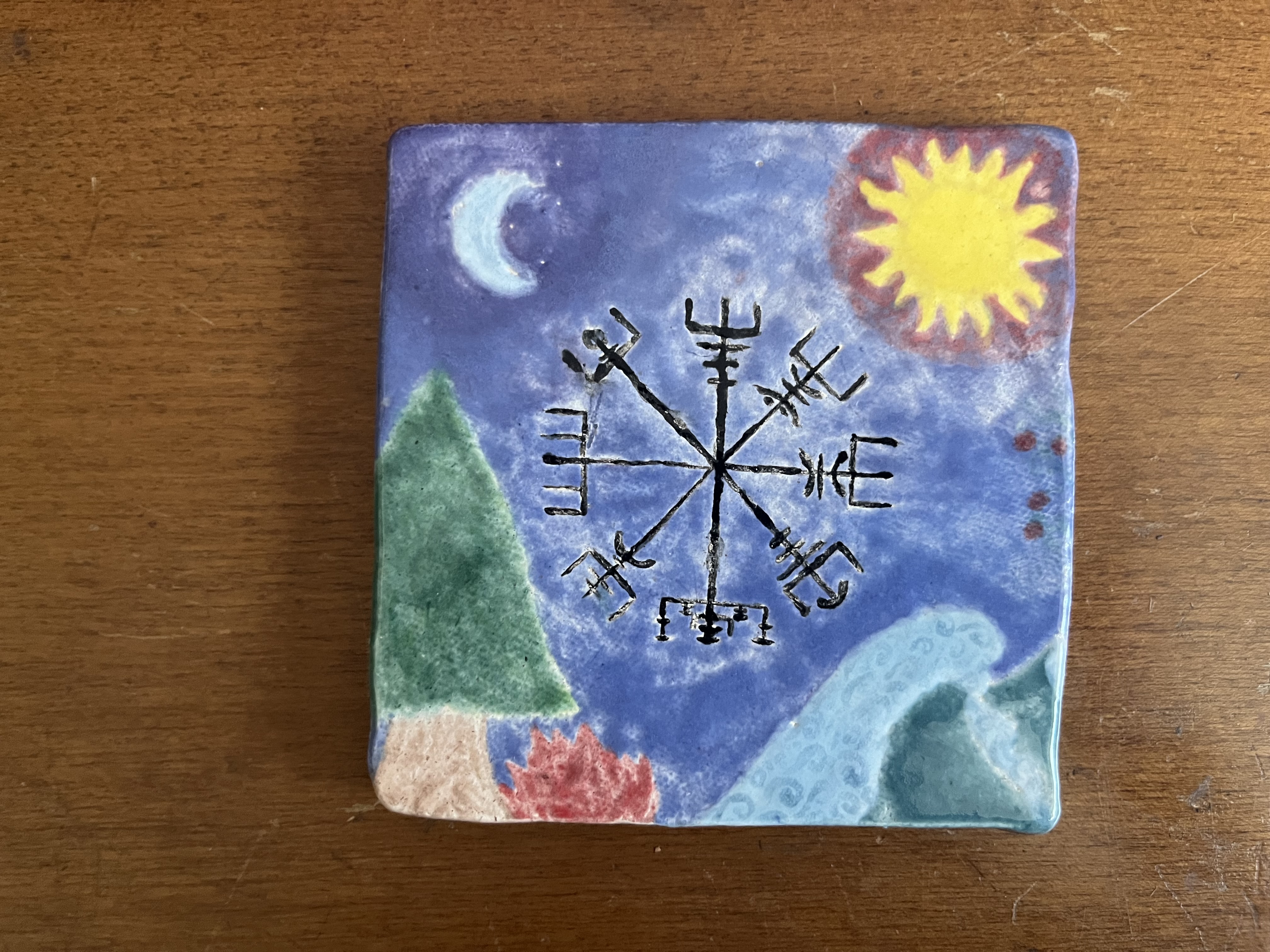 A tile depicts a Viking compass (vegvisir) surrounded by a moon, sun, conifer tree, fire, waves, and a strawberry plant